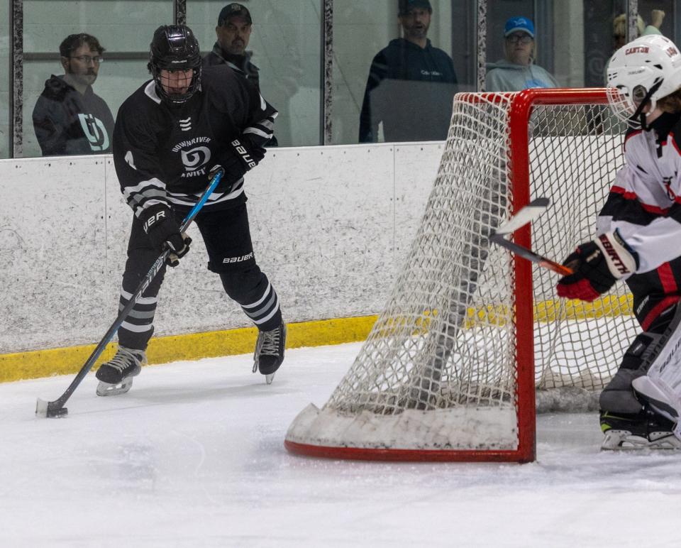 Gabe Schmidt of Monroe High handles the puck behind the net during Downriver Unified's 4-0 loss to Canton in the Division 1 Regional in Livonia Wednesday.