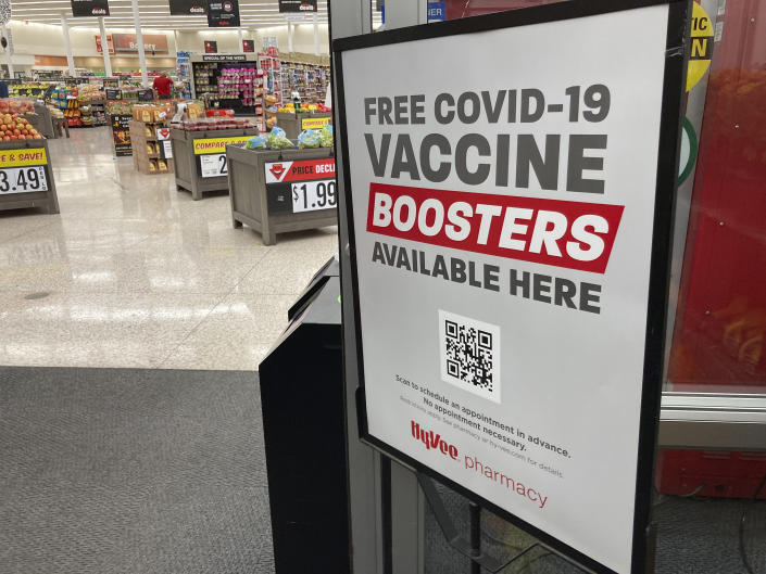 A sign advertising free COVID-19 booster shots stands at the door to a Hy-Vee grocery store in Sioux Falls, S.D., in 2021.