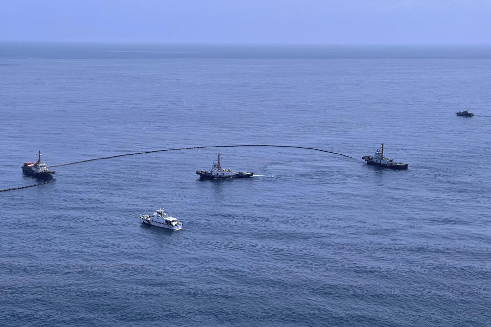 In this photo released by the Royal Thai Navy, an aerial view from a navy plane shows cleanup efforts of a large oil spill off the coast of Rayong, eastern Thailand, Thursday, Jan. 27, 2022. A special aircraft from a company specializing in recoveries from oil spills has arrived Thursday from Singapore to join an urgent effort to clean up an oil slick before it could hit beaches in eastern Thailand. (Royal Thai Navy via AP)