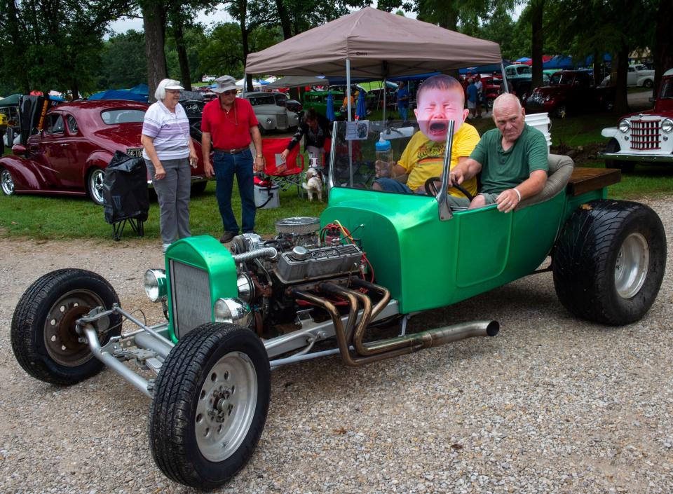 Attendees marvel at a car and masked passenger driving through the 2019 Frogs Follies.