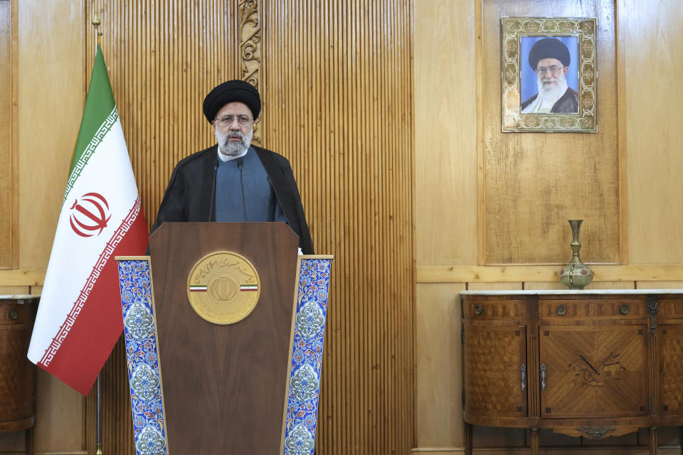 Iranian President Ebrahim Raisi speaks prior to departing Tehran's Mehrabad airport for a trip to Oman, Monday, May, 23, 2022. A portrait of the Supreme Leader Ayatollah Ali Khamenei hangs on the wall. (AP Photo/Vahid Salemi)