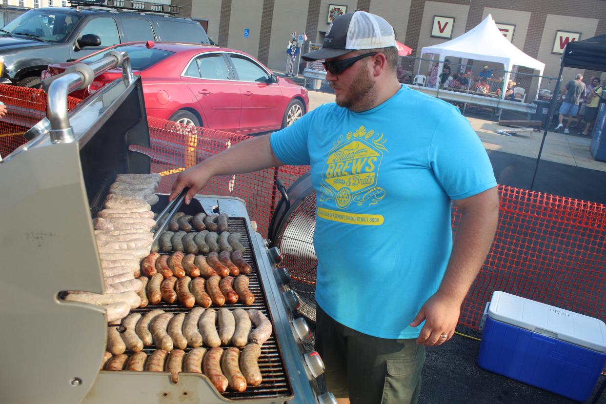 Fremont Rotarian Tim Schnitker II flips a row of bratwurst Saturday at the fifth annual Blues, Brews and Brats Festival. Organizers expected between 700 and 1,000 people at the Fremont event.