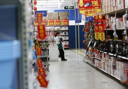 A sales promoter waits for customers at a discount department store in Beijing January 19, 2015. REUTERS/Kim Kyung-Hoon