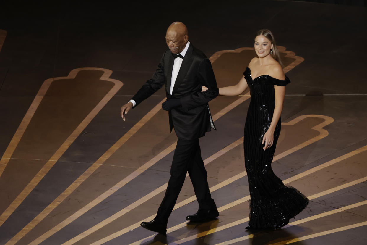 HOLLYWOOD, CALIFORNIA - MARCH 12: (L-R) Morgan Freeman and Margot Robbie walk onstage during the 95th Annual Academy Awards at Dolby Theatre on March 12, 2023 in Hollywood, California. (Photo by Kevin Winter/Getty Images)