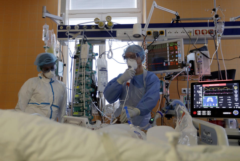 Healthcare workers attend to a COVID-19 patient at an intensive care unit (ICU) at the General University Hospital in Prague, Czech Republic, Tuesday, April 7, 2020. The new coronavirus causes mild or moderate symptoms for most people, but for some, especially older adults and people with existing health problems, it can cause more severe illness or death. (AP Photo/Petr David Josek)