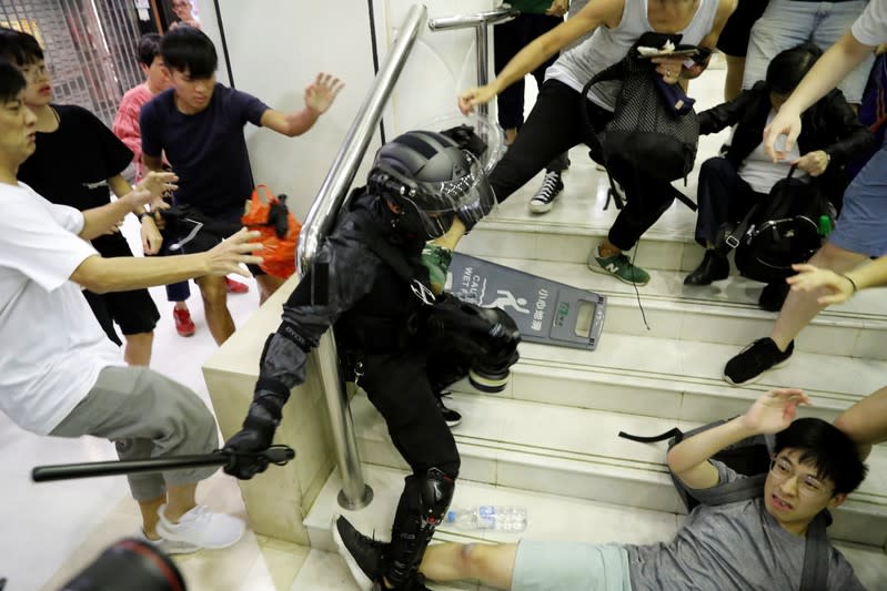 People scuffle with a riot police officer at a shopping mall in Tai Po in Hong Kong