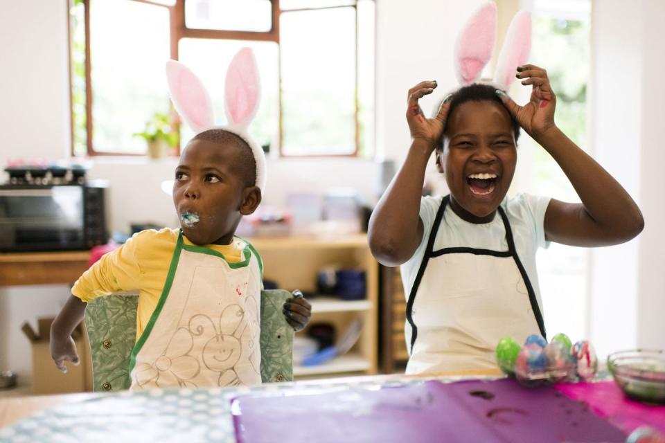 two boys laughing and decorating easter eggs