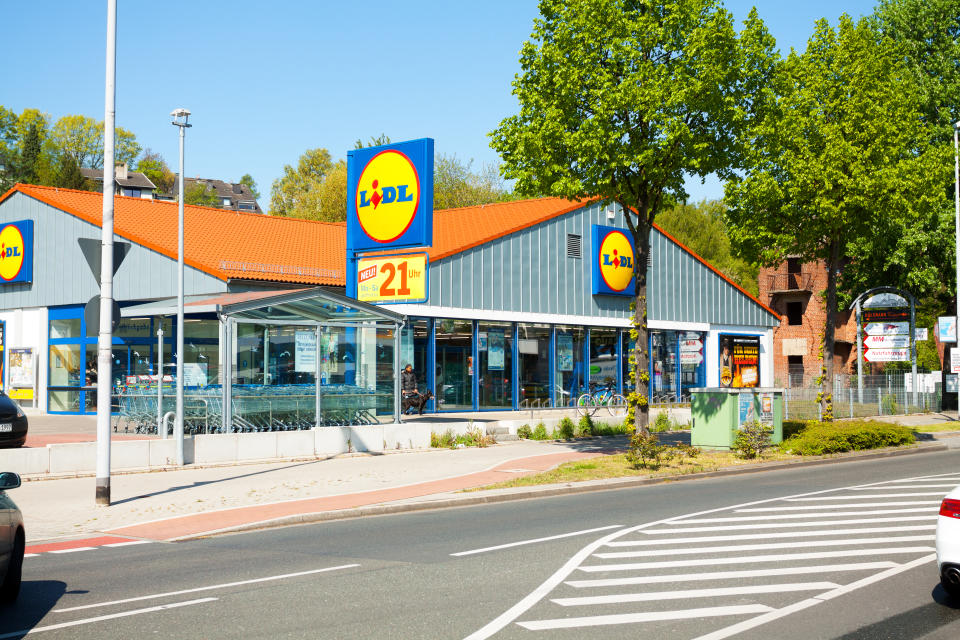 Mülheim, Germany - April 19, 2014: Capture of Lidl supermarket in Mülheim, Ruhrgebiet, View over street. A car is driving onto parking space. Outside of supermrket are people.