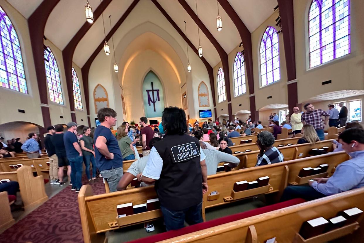 A police chaplain stands by as children from The Covenant School, a private Christian school in Nashville, Tenn., are taken to a reunification site at the Woodmont Baptist Church after a shooting at their school, on Monday, March, 27, 2023 (AP)