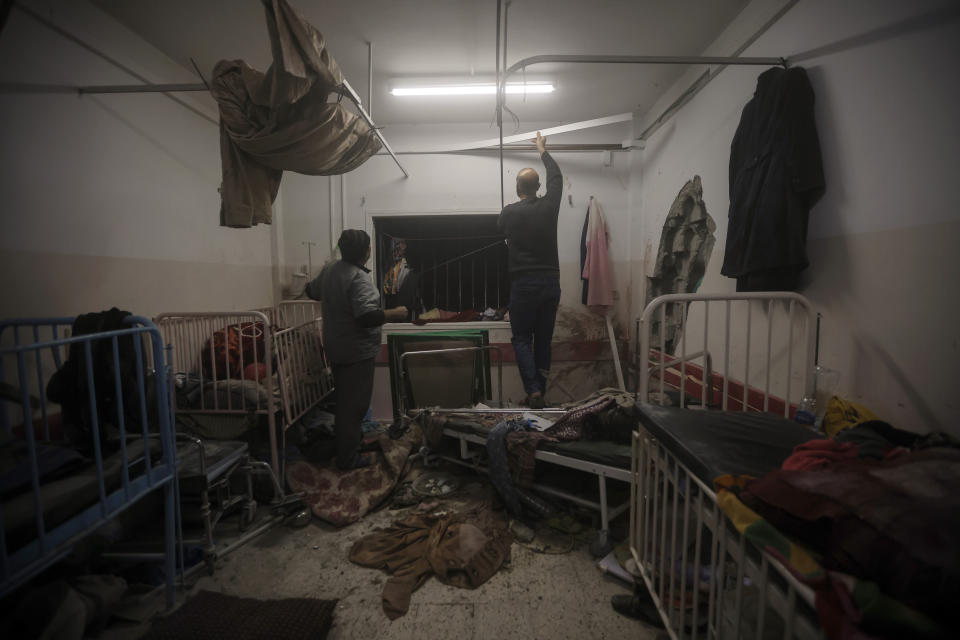 Palestinian paramedics inspect damage in the patient rooms caused by the Israeli strikes on the maternity ward at Nasser Hospital in the town of Khan Younis, southern Gaza Strip, Sunday, Dec. 17, 2023. (AP Photo/Mohammed Dahman)