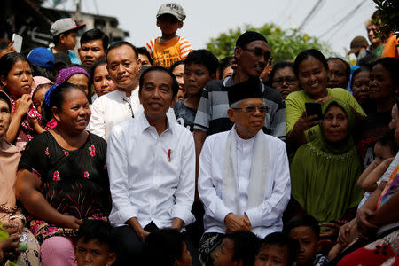 Indonesia's Incumbent President Joko Widodo (C-L) and his running mate Ma'ruf Amin (C-R) sit among people before making a public address following the announcement of the last month's presidential election results at a rural area of Jakarta, Indonesia, May 21, 2019. REUTERS/Willy Kurniawan