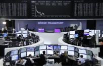 Traders work at their screens in front of the German share price index, DAX board, at the stock exchange in Frankfurt, Germany, October 13, 2015. REUTERS/Staff/remote