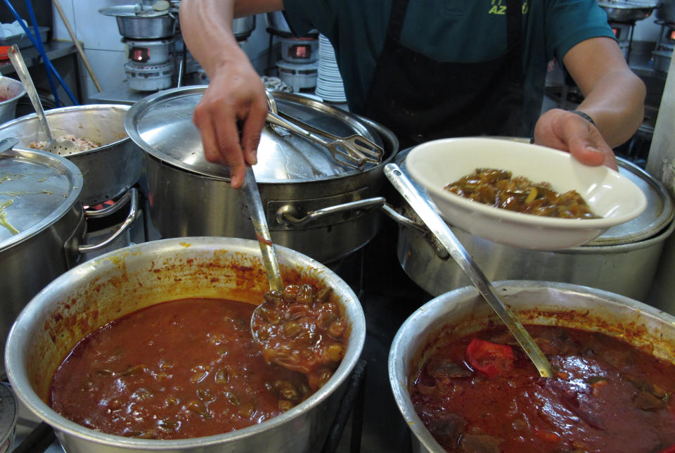 In this photo take Wednesday, March, 26, 2014, a cook prepares a dish in the kitchen of at the Azura restaurant in Jerusalem's Mahane Yehuda market. The family-run institution is famous for its Turkish-inspired delicacies that are slow-cooked to perfection atop kerosene burners. (AP Photo/Aron Heller)