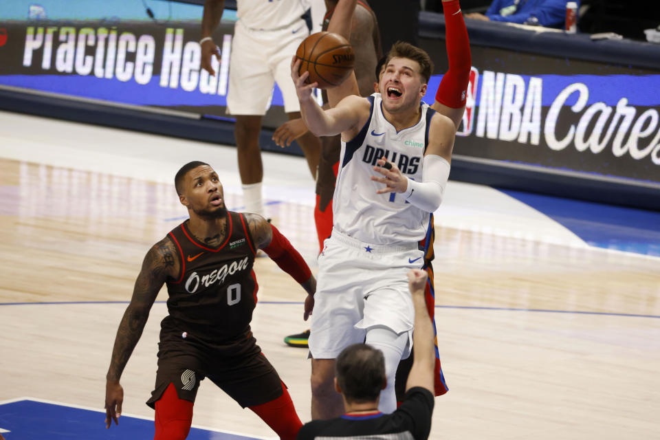 Portland Trail Blazers guard Damian Lillard watches as Dallas Mavericks guard Luka Doncic makes a basket