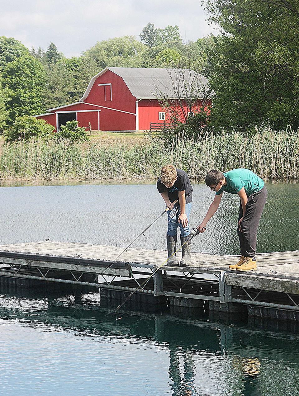 Aiden Sumler and Quentin Craft decompress while fishing at Pathfinder Farms. Students also hike, paint and do other activities as part of the self-care component to the farm's faith-based youth programs.