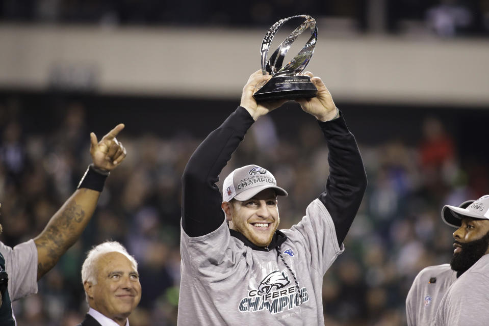 The Eagles’ Carson Wentz holds the George Halas Trophy after the NFC championship game against the Minnesota Vikings on Sunday, Jan. 21, 2018, in Philadelphia. (AP Photo/Matt Rourke)