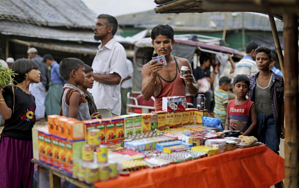 In this photograph taken Aug. 27, 2018, a Rohingya man looks at medicines being sold on the roadside in Balukhali refugee camp, Bangladesh. Faith healers have long been sought out in Rohingya society to treat physical and mental ailments. Their trade has thrived in part because of traditional beliefs and in part because Rohingya have lacked access to modern medical care in Buddhist-majority Myanmar, where they are one of the most persecuted minority groups in the world. Access to medical care has changed for the better in the refugee camps in Bangladesh, yet many Rohingya still seek out their faith healers. (AP Photo/Altaf Qadri)