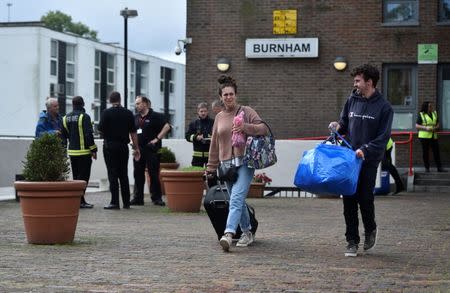 Residents are evacuated from the Burnham Tower residential block as a precautionary measure following concerns over the type of cladding used on the outside of the building on the Chalcots Estate in north London, Britain, June 24, 2017. REUTERS/Hannah McKay