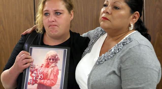 Pearl Nelson, left, holds a photo of her late mother Audrey Nelson, with Mary Louise Frias, goddaughter of another victim. Picture: AP