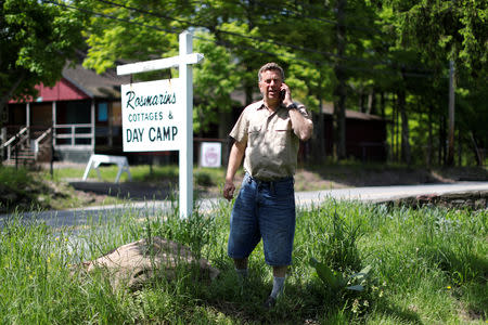 FILE PHOTO: Scott Rosmarin, owner and operator of Rosmarins Day Camp and Cottages, talks on the phone on the camp grounds in Monroe, New York, U.S., May 20, 2019. Picture taken May 20, 2019. REUTERS/Mike Segar