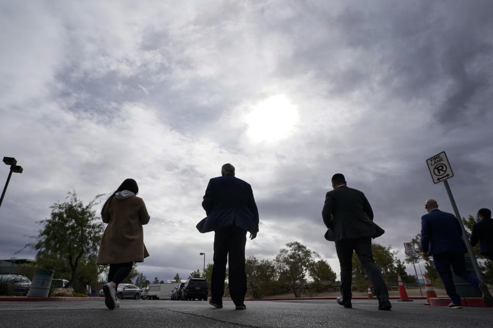 Nevada Gov. Steve Sisolak, second from left, leaves a campaign event flanked by staff members and security officials Tuesday, Nov. 8, 2022, in Las Vegas. (AP Photo/Gregory Bull)