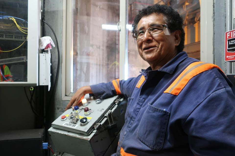 In this Aug. 20, 2019, image, Peabody Energy silo operator Gerald Clitso talks with coworkers after loading coal into a train bound for the Navajo Generating Station near Page, Ariz. The power plant will close before the year ends, upending the lives of hundreds of mostly Native American workers who mined coal, loaded it and played a part in producing electricity that powered the American Southwest. (AP Photo/Felicia Fonseca)