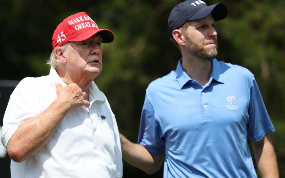 Donald Trump and Eric Trump wait together during the pro-am prior to the LIV Golf Invitational - Bedminster - Getty