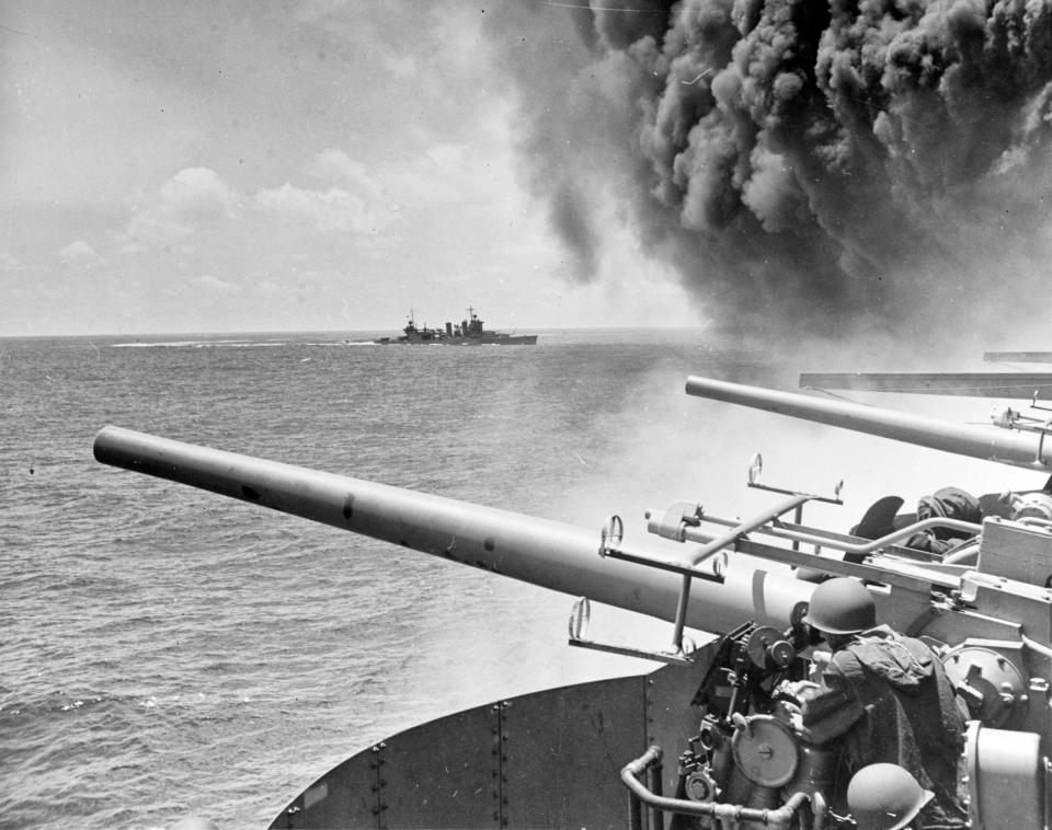 FILE - In this June 4, 1942 file photo provided by the U.S. Navy the USS Astoria (CA-34) steams by USS Yorktown (CV-5), shortly after the carrier had been hit by three Japanese bombs in the battle of Midway. Researchers scouring the world's oceans for sunken World War II ships are honing in on debris fields deep in the Pacific. A research vessel called the Petrel is launching underwater robots about halfway between the U.S. and Japan in search of warships from the Battle of Midway. (William G. Roy/U.S. Navy via AP, File)