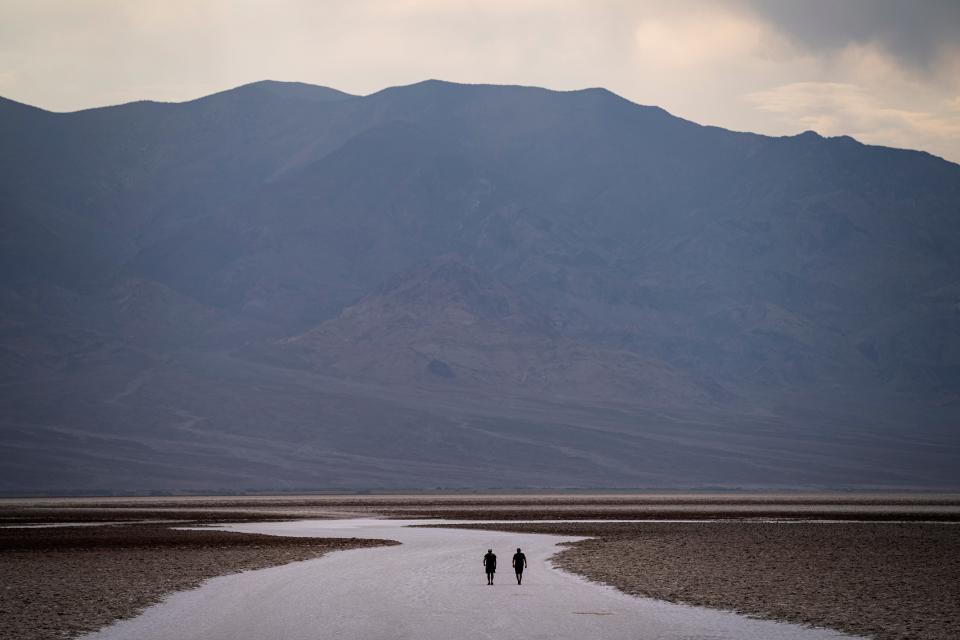 People walk on salt flats in Badwater Basin in Death Valley National Park, Calif. Death Valley, in southeastern California's Mojave Desert