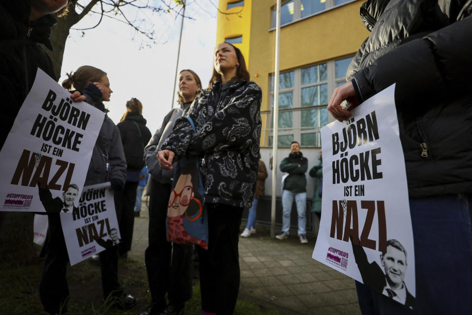 Protestors hold banners reading 'Bjoern Hoecke is a nazi' outside the state court in Halle, Germany, Thursday, April 18, 2024. Bjoern Hoecke, goes on trial at the state court in Halle on charges related to his alleged use in a 2021 speech of a slogan used by the Nazis' SA stormtroopers. (Fabrizio Bensch/Pool via AP)