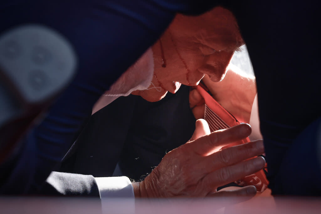 Republican presidential candidate former President Donald Trump is shown covered by U.S. Secret Service agents after an incident during a rally on July 13, 2024, in Butler, Pennsylvania.