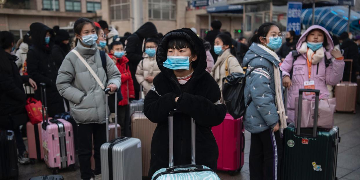 Chinese children wear protective masks as they wait to board trains at Beijing Railway station before the annual Spring Festival on January 21, 2020 in Beijing, China.