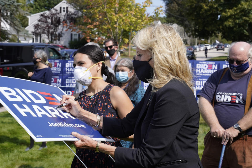 Jill Biden, front right, wife of Democratic presidential candidate former vice president Joe Biden, signs a campaign placard during a campaign stop, Wednesday, Sept. 16, 2020, in Manchester, N.H. (AP Photo/Steven Senne)