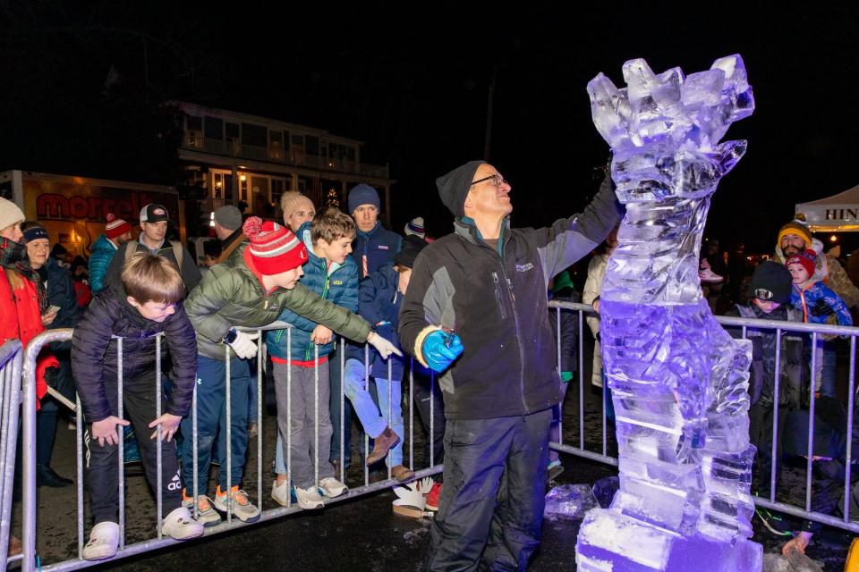 Spectators gather to see Donald Chapelle, of North Andover, create a stoic deer ice sculpture during Christmas in the Square in downtown Hingham on Friday, Dec. 2, 2022.