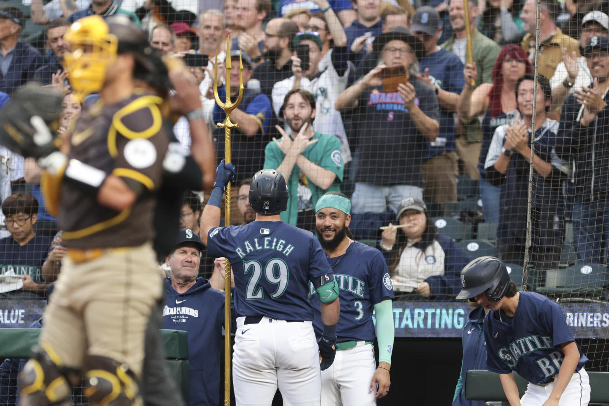 Seattle Mariners' Cal Raleigh (29) celebrates with manager Dan Wilson, center left, and J.P. Crawford (3) after hitting a solo home run off San Diego Padres starting pitcher Yu Darvish during the first inning of a baseball game, Tuesday, Sept. 10, 2024, in Seattle. (AP Photo/Jason Redmond)