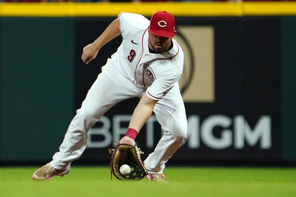 Cincinnati Reds first baseman Mike Moustakas (9) fields a groundball during the eighth inning of a baseball game against the Pittsburgh Pirates, Thursday, July 7, 2022, at Great American Ball Park in Cincinnati.