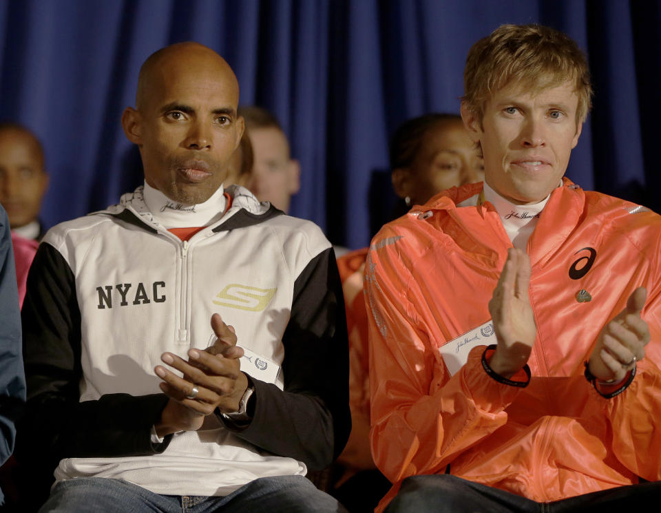 Boston Marathon runners Meb Keflezighi and Ryan Hall applaud during introductions at a media availability of Boston Marathon elite runners at the Copley Plaza Hotel in Boston Friday April 18, 2014. The 118th running of the Boston Marathon is Monday April 21, 2014. (AP Photo/Stephan Savoia)