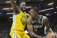 Golden State Warriors forward Draymond Green (23) guards Sacramento Kings guard De'Aaron Fox (5) during the second half of an NBA basketball game in Sacramento, Calif., Sunday, Oct. 24, 2021. The Warriors won 119-107. (AP Photo/Randall Benton)