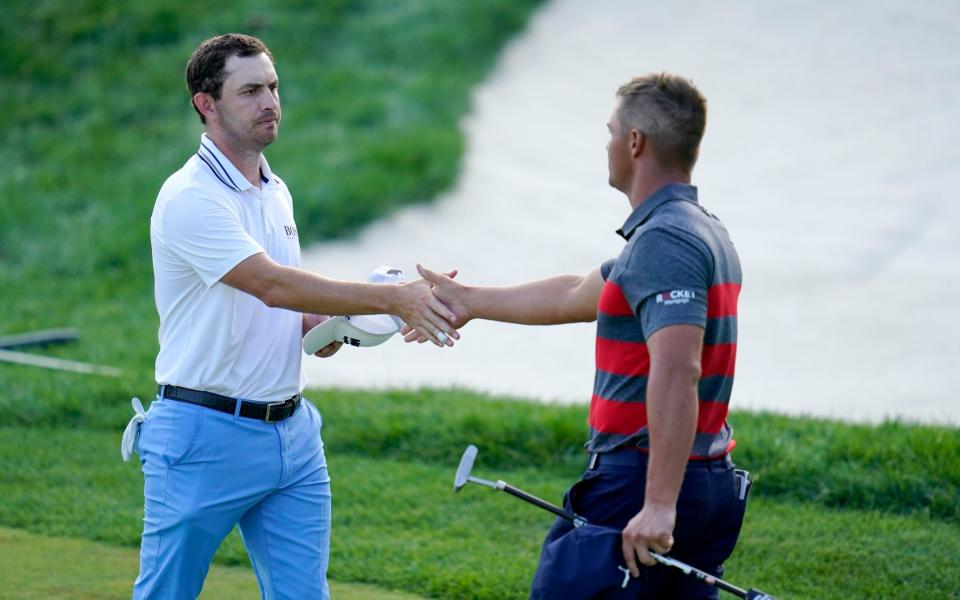Patrick Cantlay, left, and Bryson DeChambeau shake hands after they completed the 18th hole - AP
