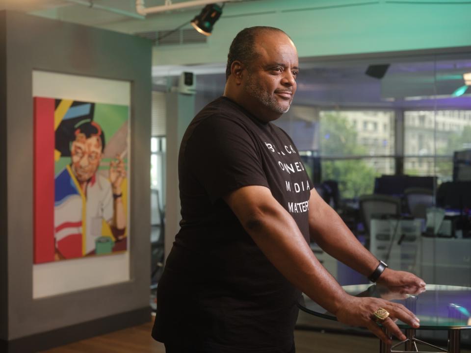 A man poses inside of a TV network studio.