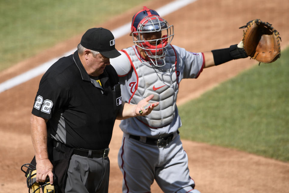 Washington Nationals catcher Kurt Suzuki, right, signals for assistance after umpire Joe West (22) was injured during the first inning of a baseball game against the Toronto Blue Jays, Thursday, July 30, 2020, in Washington. (AP Photo/Nick Wass)