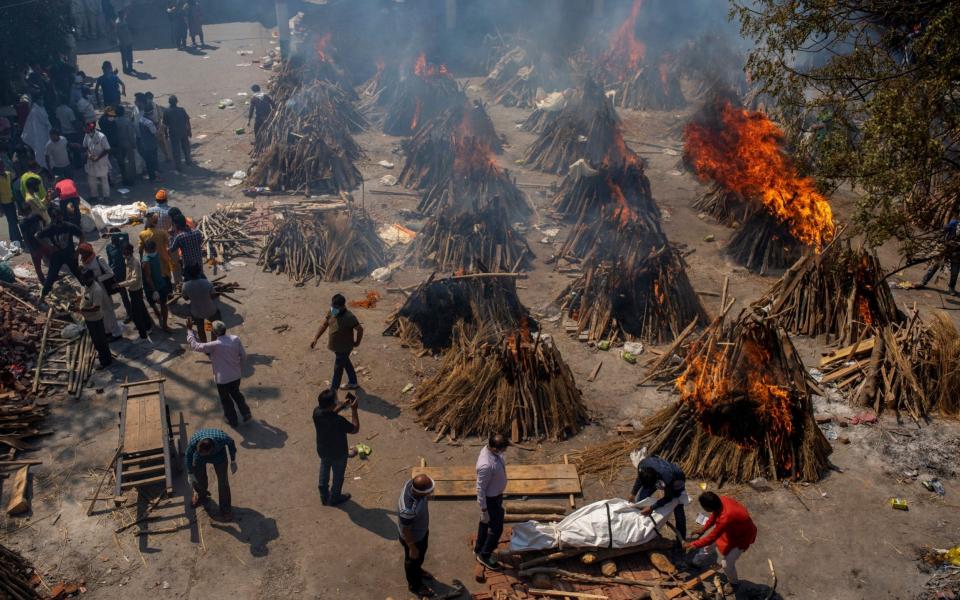 Funeral pyres of victims of Covid burn at a ground that has been converted into a crematorium for mass cremation in New Delhi - Altaf Qadri/AP