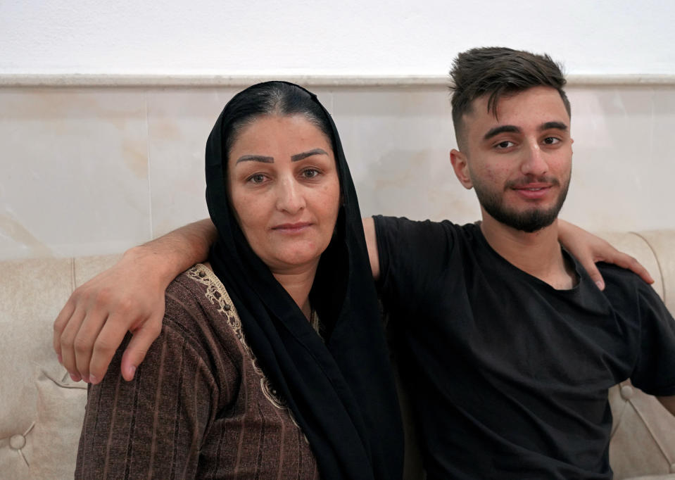 Sarkawt Selim, 19, who returned recently from Minsk after failing to cross the border into Poland, sits with his mother Adla, in their house in Dahuk, Iraq, Friday, Nov. 19, 2021. Rising unemployment, endemic corruption and a recent economic crisis that slashed state salaries have pushed Iraqi Kurds to sell their homes, cars and other belongings to pay off smugglers with the hope of reaching the European Union from the Belarusian capital of Minsk. (AP Photo/Rashid Yahya)