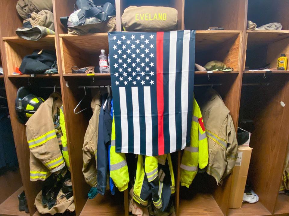 A thin red line flag covers the locker of a fallen firefighter.