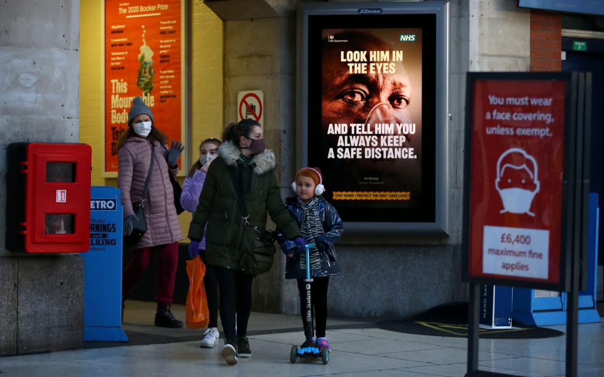 Child walks with mother down street - HOLLIE ADAMS /AFP