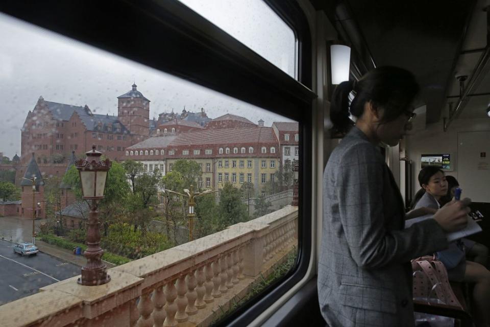 Staff members ride on a train in the Huawei's Ox Horn campus