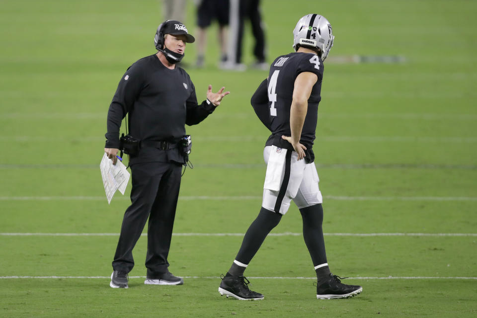 Las Vegas Raiders head coach Jon Gruden, left, speaks with quarterback Derek Carr (4) during the second half of an NFL football game, Monday, Sept. 21, 2020, in Las Vegas. (AP Photo/Isaac Brekken)