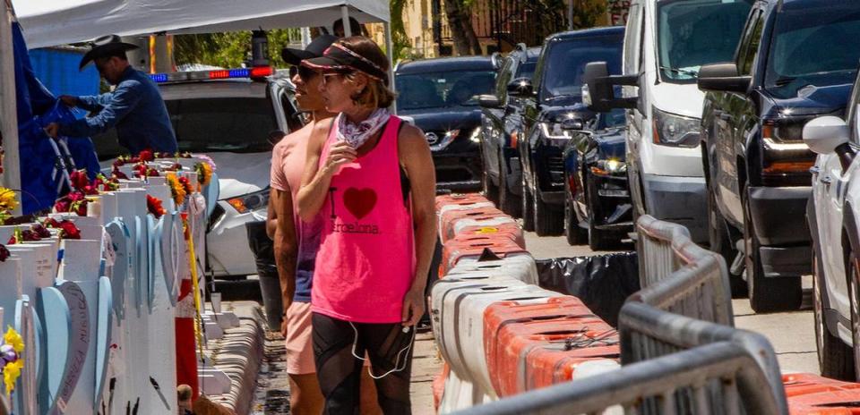 People visit the memorial wall for the victims of the Champlain Towers South as workers keep removing debris from the rubbles 23 days after the building collapsed in Surfside, on Saturday, July 17, 2021.