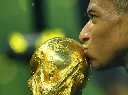 Soccer Football - World Cup - Final - France v Croatia - Luzhniki Stadium, Moscow, Russia - July 15, 2018 France's Kylian Mbappe kisses the trophy as he celebrates winning the World Cup REUTERS/Dylan Martinez