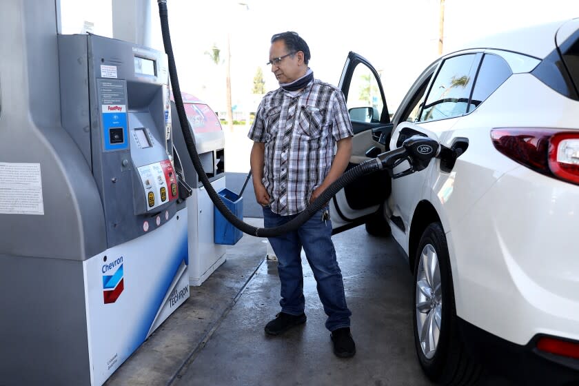 ORANGE, CA - MARCH 08: Juan Galaiviz, of Santa Ana pumps gas into his automobile at the Chevron gas station along Katella Ave. and Glassell on Tuesday, March 8, 2022 in Orange, CA. Galaiviz paid $50.00 for 8.866 gallons of regular gasoline. Juan drove from Santa Ana because it was less expensive in Orange. The average price of a gallon of self-serve regular gasoline in Los Angeles County rose 8.9 cents today, its 30th record in 32 days. In Orange County average price rose 8.8 cents, its 29th record in 34 days. (Gary Coronado / Los Angeles Times)